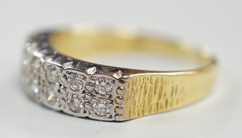 A modern 18ct gold and fourteen stone two row diamond set half hoop ring, size R/S, with textured shoulders, gross weight 5.4 grams.